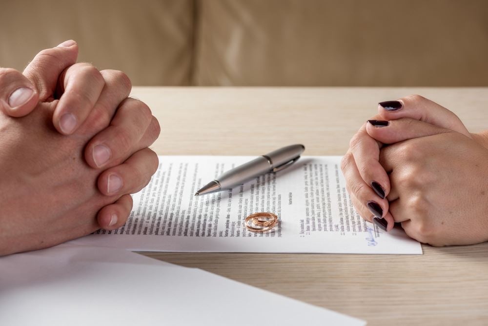 Divorce papers, pen and wedding rings